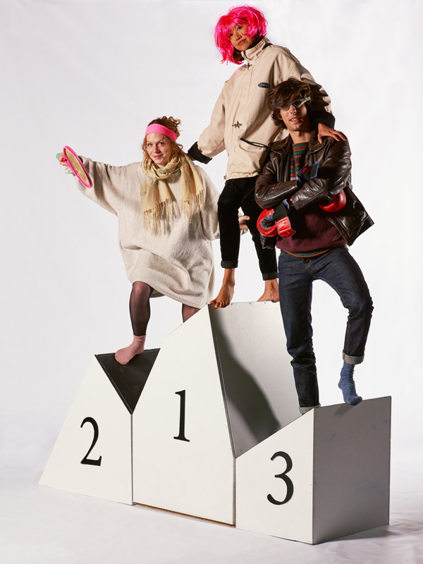 Trois personnes déguisées en équilibre sur un podium déstructuré