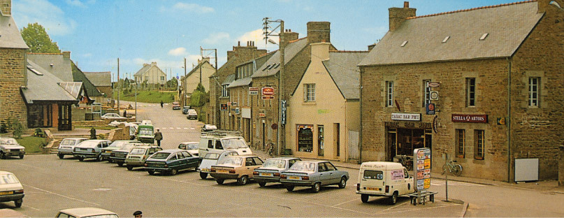 Vue de la place du bourg de Ploumagoar dans les années 1980, avec des voitures stationnées et le bar-tabac PMU visible sur la droite.