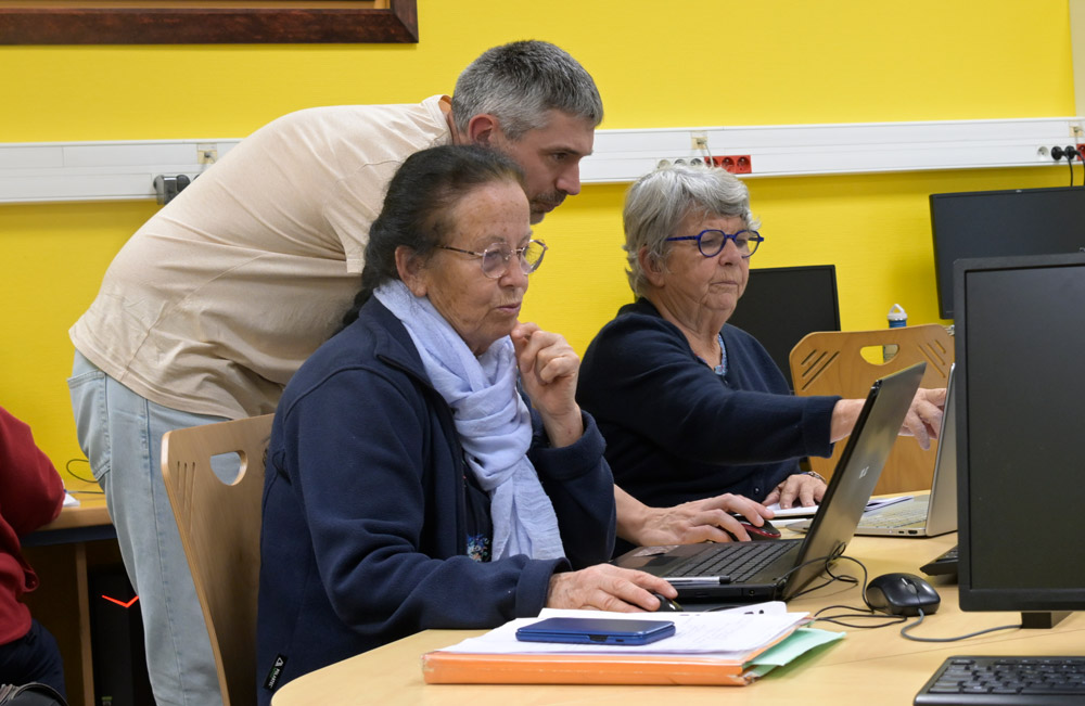 Deux femmes et un homme devant un écran.